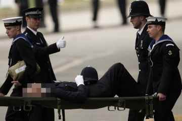 Ein Polizist wurde auf einer Trage getragen, nachdem er während der Beerdigung der Königin zusammengebrochen war