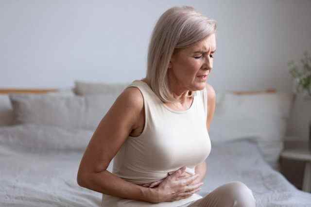 Reife Frau, die Magenschmerzen durch eine Fettlebererkrankung hat
