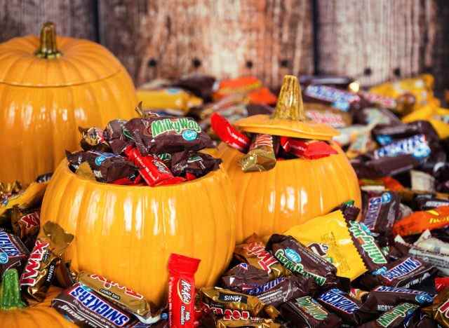 dekorative Kürbisse gefüllt mit verschiedenen Halloween-Süßigkeiten