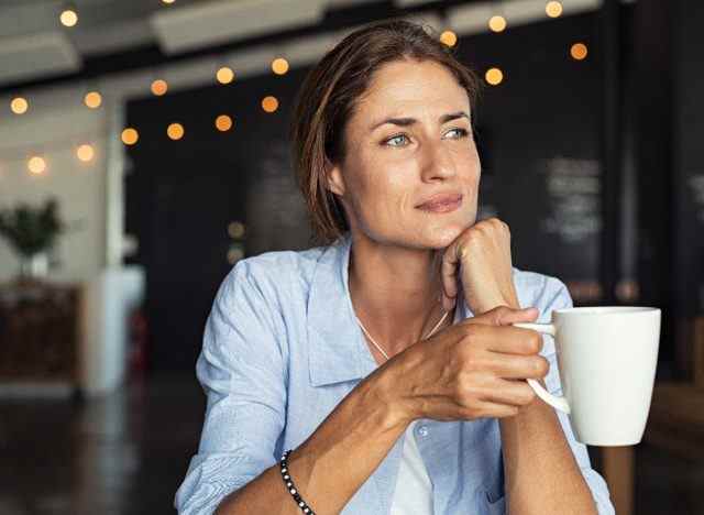 Frau mit Kaffeebecher im Café