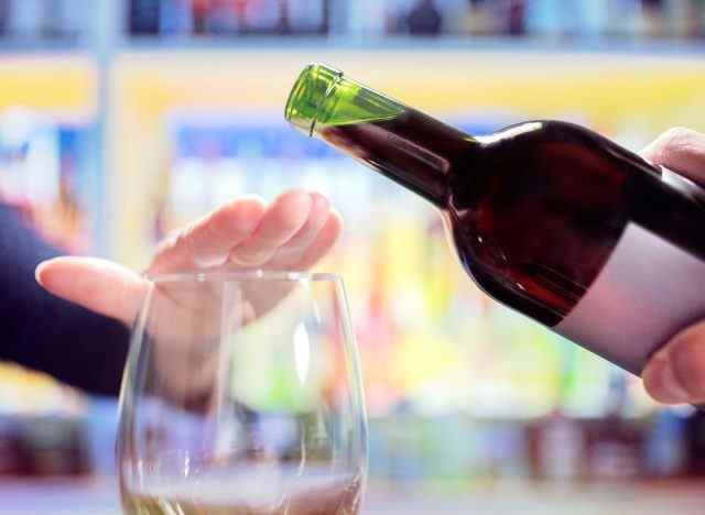 Konzept der Begrenzung des Alkoholkonsums, nein sagen zu zusätzlichem Wein, um Ihre Bauchwölbung zu schmelzen