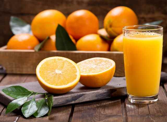 Orangen mit Glas Orangensaft