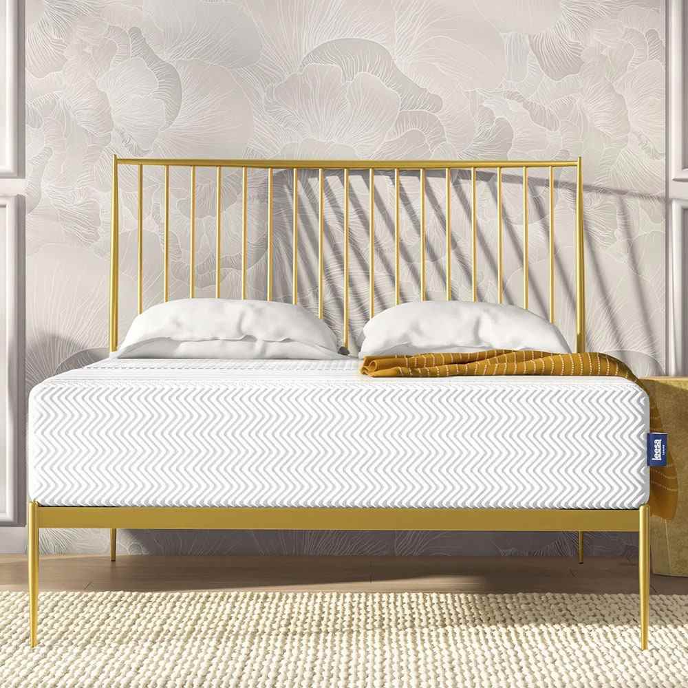 White mattress on gold bed frame