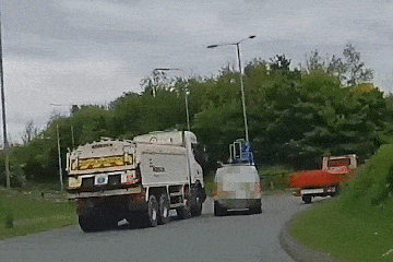 Beobachten Sie, wie der Lieferwagen vor einem massiven Lastwagen ausweicht, bevor er auf das Dach kippt