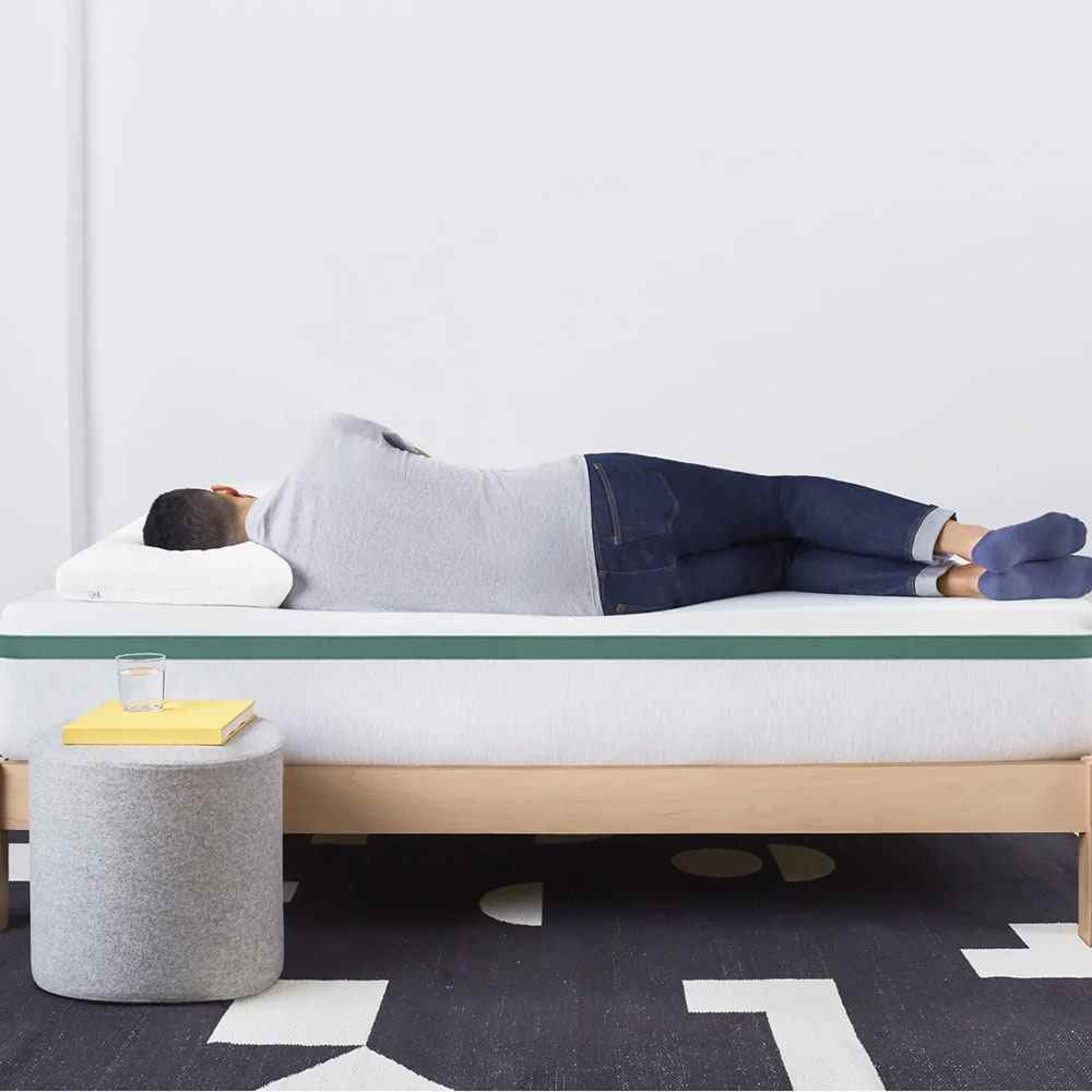 Person laying on white and green mattress
