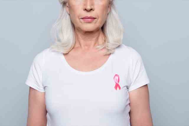 frau im weißen t-shirt mit rosa band des brustkrebses