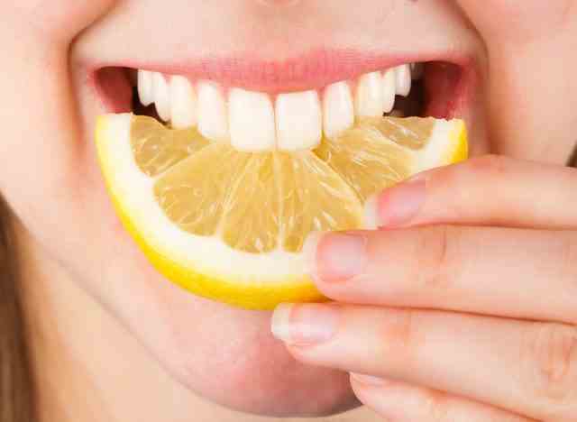 Zähne beißen in Zitrone