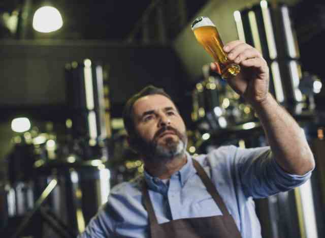 Brauereiarbeiter, der Bier untersucht
