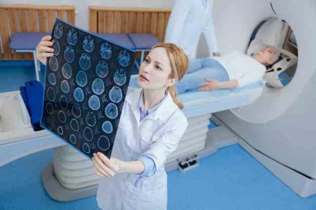 Radiologe, der sich die MRI-Scan-Bilder ansieht.