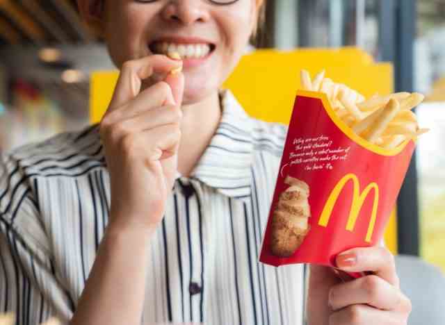 Frau isst McDonalds-Pommes