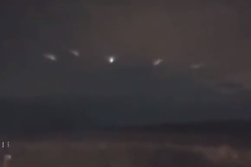 Kugelähnliche UFOs, die in Formation über der Landschaft fliegen und eine Sonde auslösen