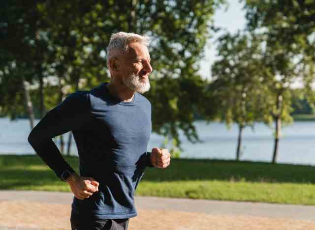 älterer Mann, der an einem sonnigen Tag im Freien joggt
