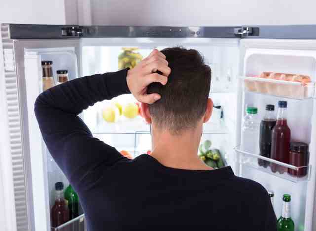 Mann, der im Kühlschrank schaut