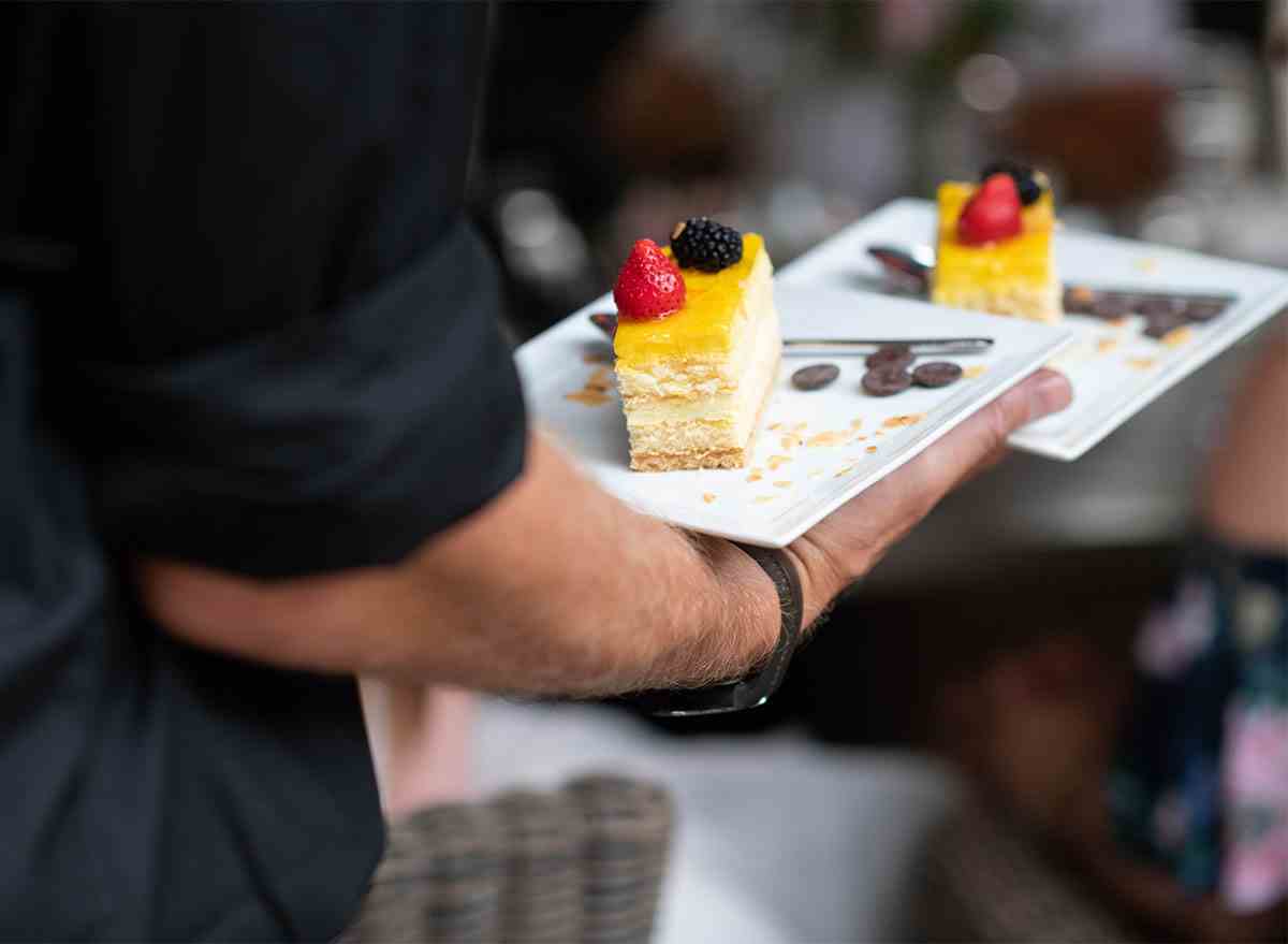 waiter carrying two cake slices