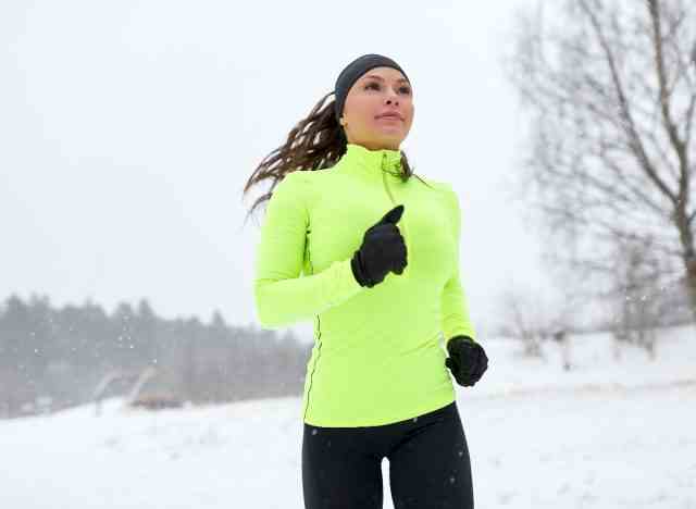 frau auf verschneitem winterlauf, um urlaubsgewicht zu verlieren