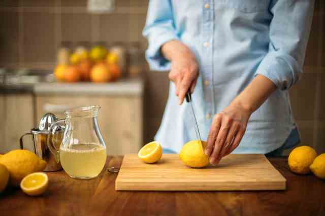 Junge Frau, die Zitronen in der Küche schneidet