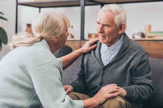älterer Mann mit Demenz im Gespräch mit Pflegekraft