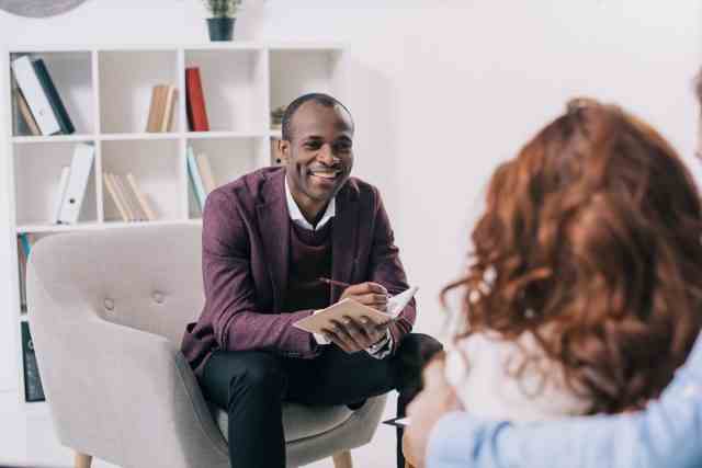 Afroamerikanischer Psychiater im Gespräch mit jungem Paar