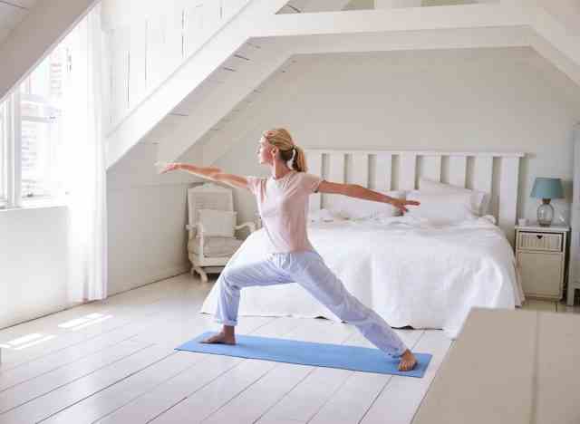 Frau, die Yoga-Schlafzimmer ausdehnt