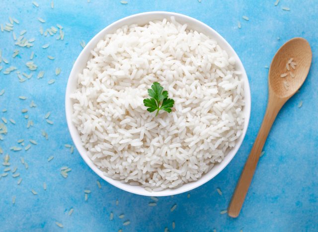 weißer Reis in Schüssel mit Holzlöffel