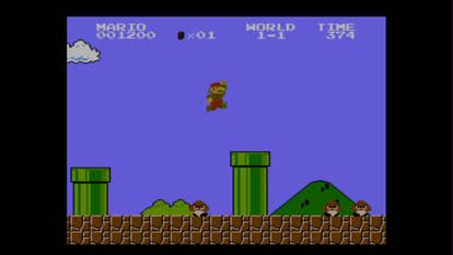 Beste Mario-Spiele - Screenshot von Super Mario Bros., der zeigt, wie Mario im klassischen 1-1-Level über ein Rohr springt.