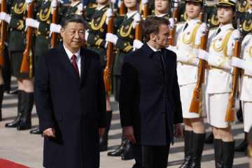 Emmanuel Macron steht neben Xi Jinping, der als „Marionette Chinas“ gebrandmarkt wird