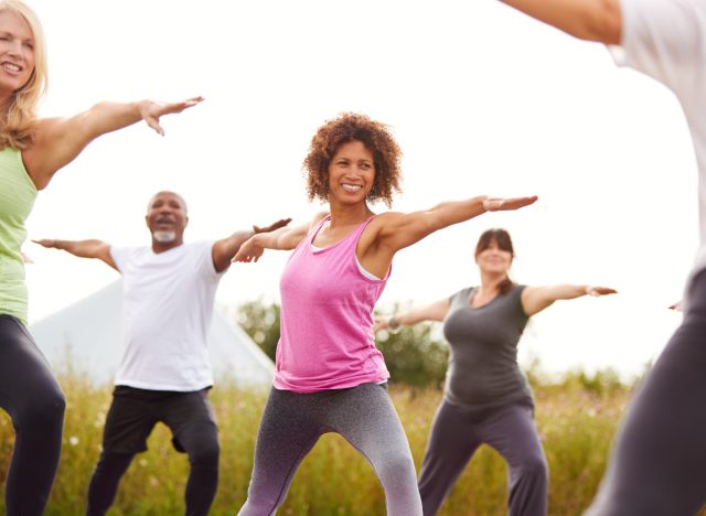 fitnessgruppe macht yoga im freien