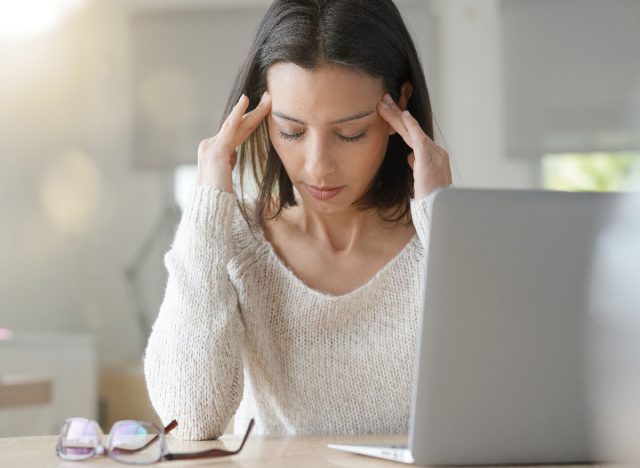 Frau gestresst am Schreibtisch mit Laptop