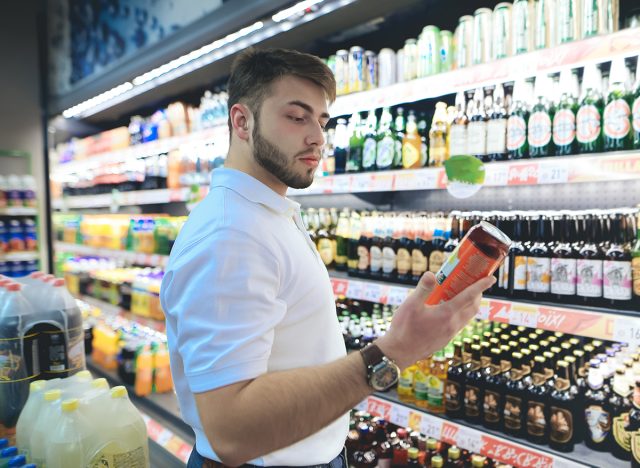 Mann wählt Bier in einem Supermarkt