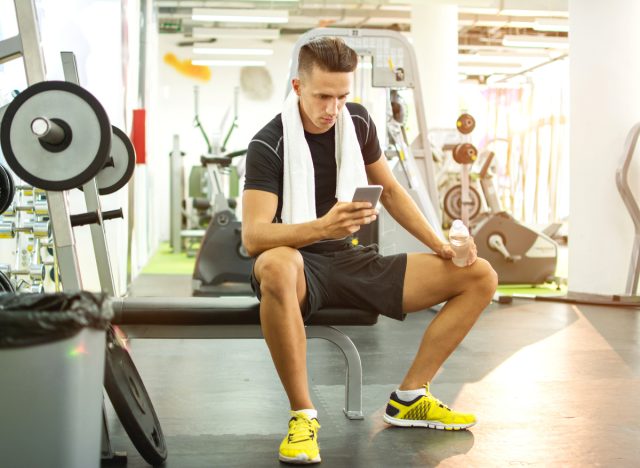 Mann schreibt im Fitnessstudio SMS