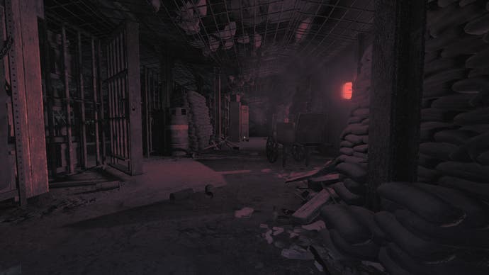 Amnesia: The Bunker-Rezensionsscreenshot, in dem ein rotes Licht einen blutigen Glanz auf Sandsäcke, eine Gaskartusche und verstreute zerbrochene Gegenstände auf dem Boden wirft.