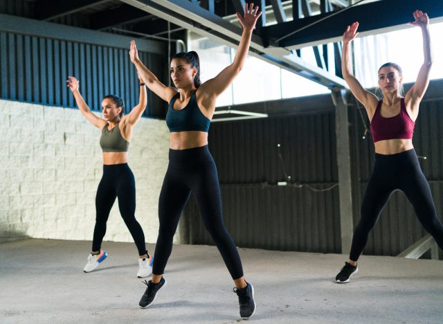 Frauen machen Jumping Jacks im Fitnesskurs