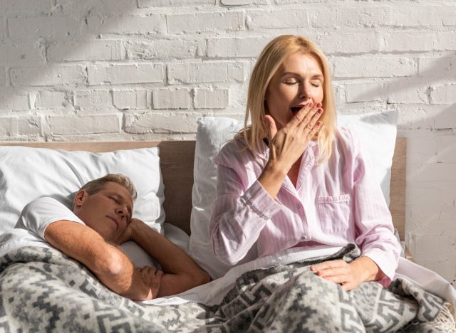 Müde reife Frau gähnt im Bett, Konzept von Gewohnheiten, die den Fortschritt beim Abnehmen zerstören