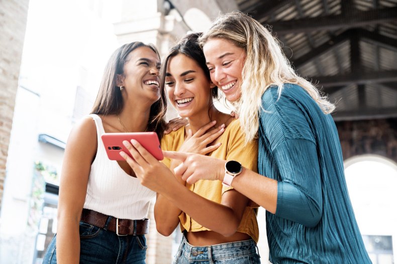 Women smiling looking at smartphone. 