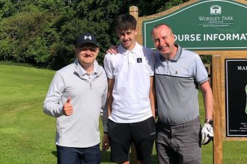 Andy Whyment von Corrie posiert mit seinem gleichartigen Sohn und seinem Co-Star beim Golfspielen