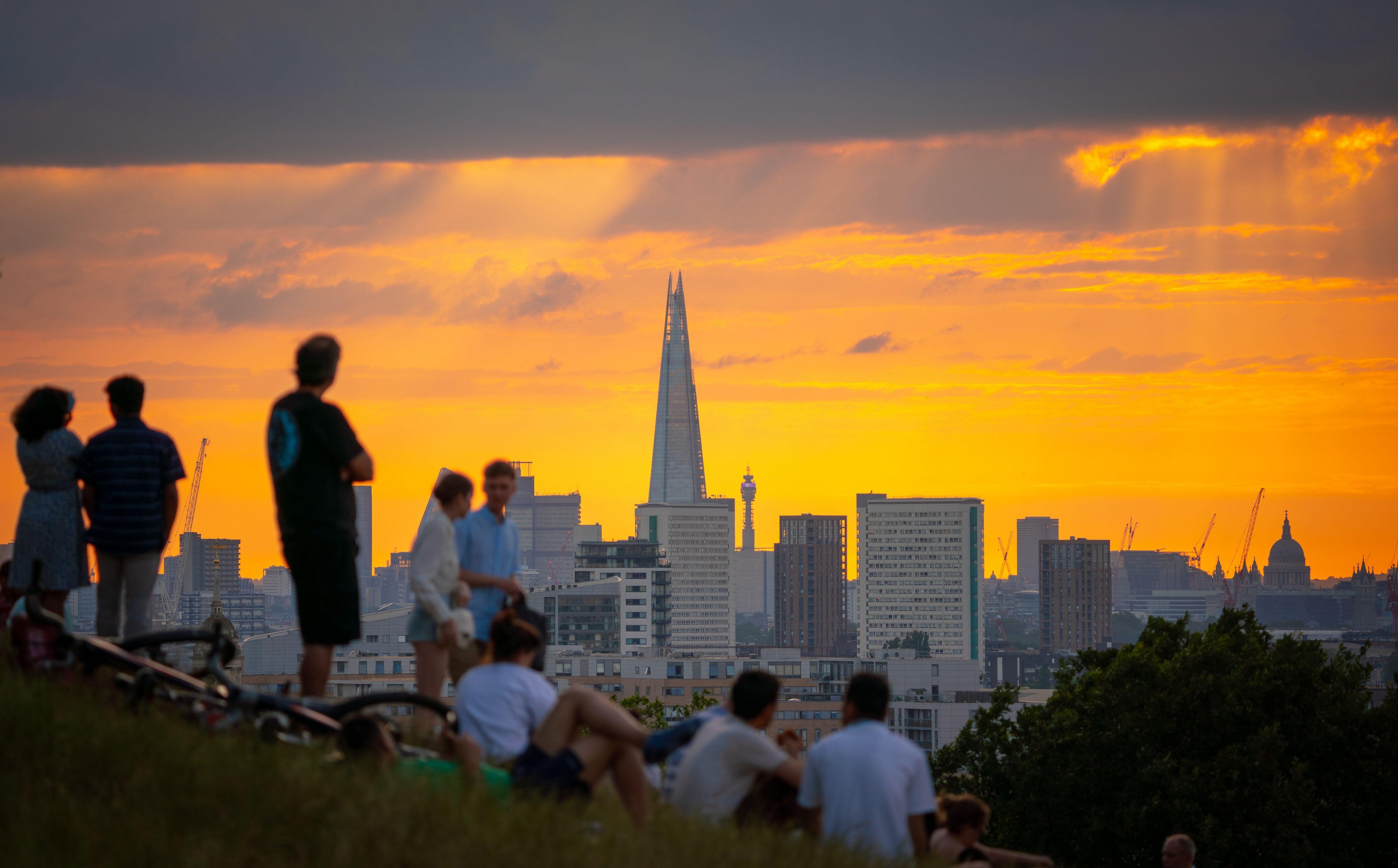 Briten genießen am Sonntagabend oben im Greenwich Park in London einen spektakulären Sonnenuntergang