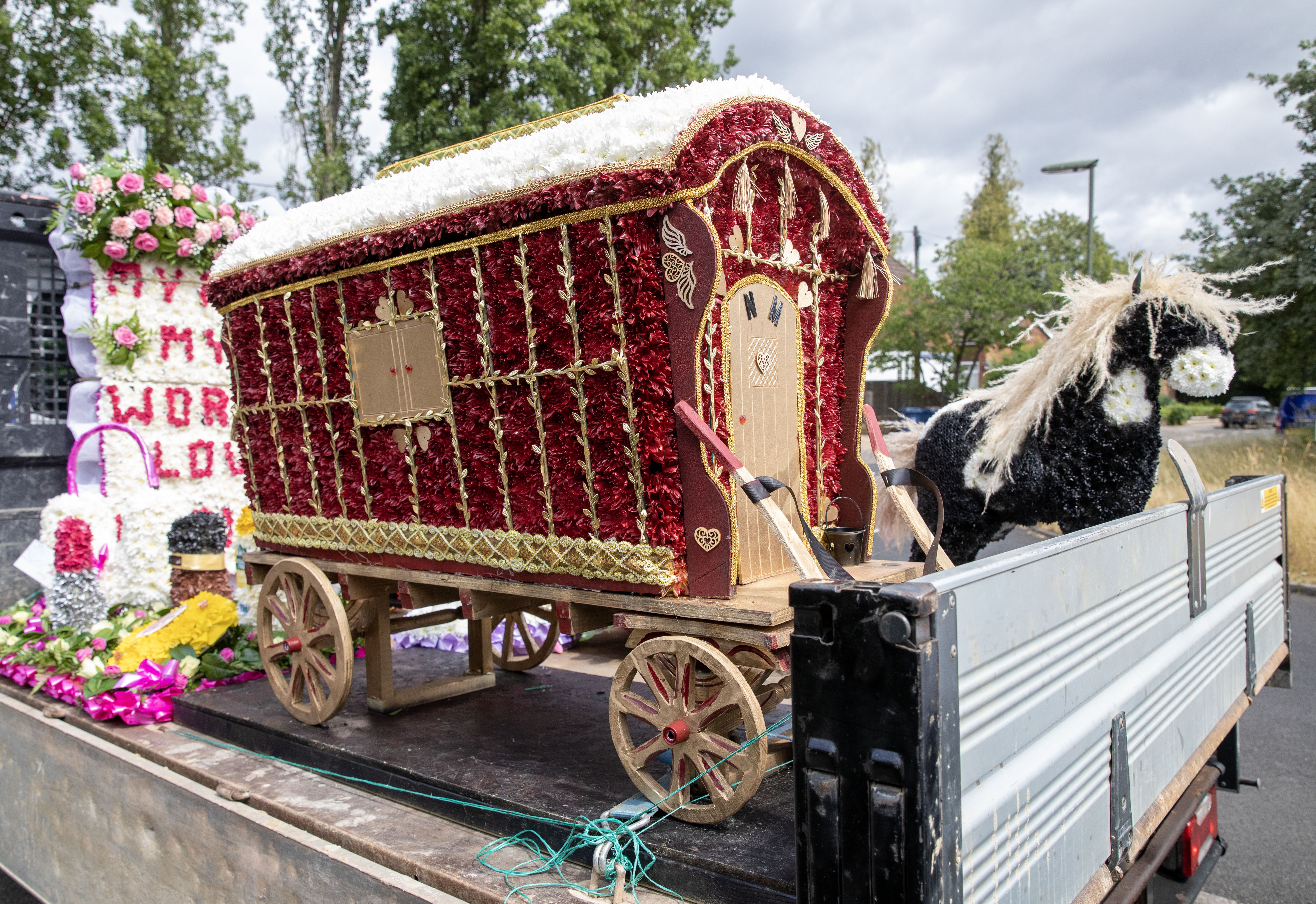 Zwei Miniatur-Zigeunerwagen, geschmückt mit roten und weißen Blumen