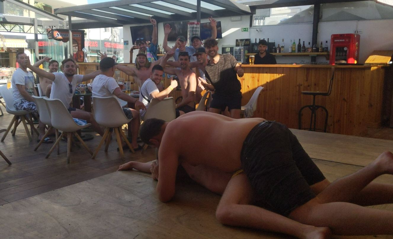 Männer feuern ihre Kumpels an, die auf dem Boden eines Restaurants zu ringen scheinen