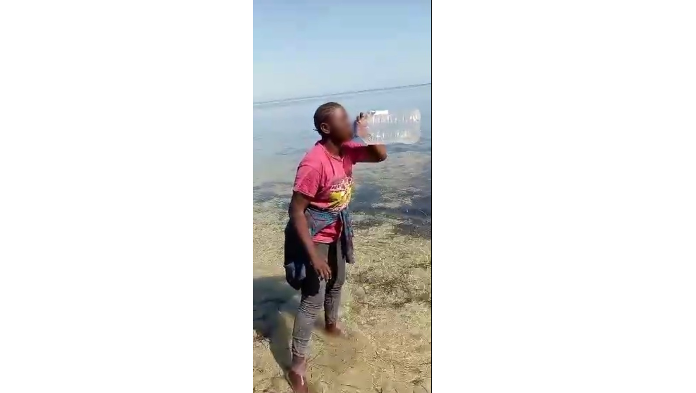 Dies ist ein Screenshot eines Videos, das ein junges Mädchen zeigt, das am 6. Juli Meerwasser trinkt.