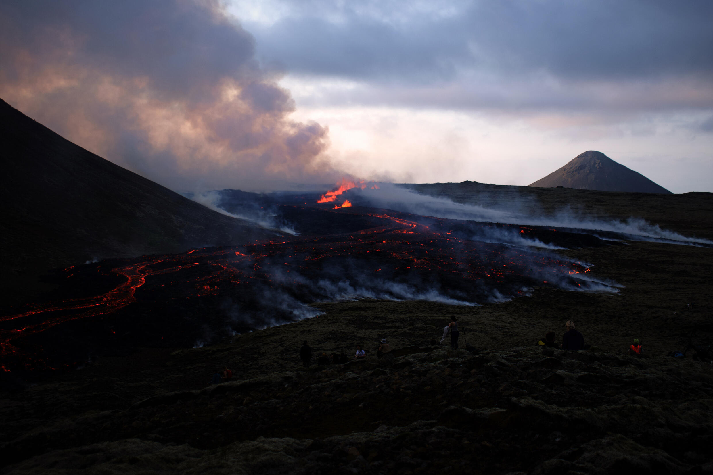 Menschen beobachten die Lava eines Vulkanausbruchs in der Nähe des Litli Hrutur-Gipfels, Island.