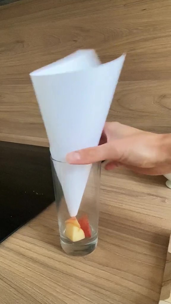 Geben Sie den Apfel in ein Glas und legen Sie dann zu einer Tüte gerolltes Papier hinein