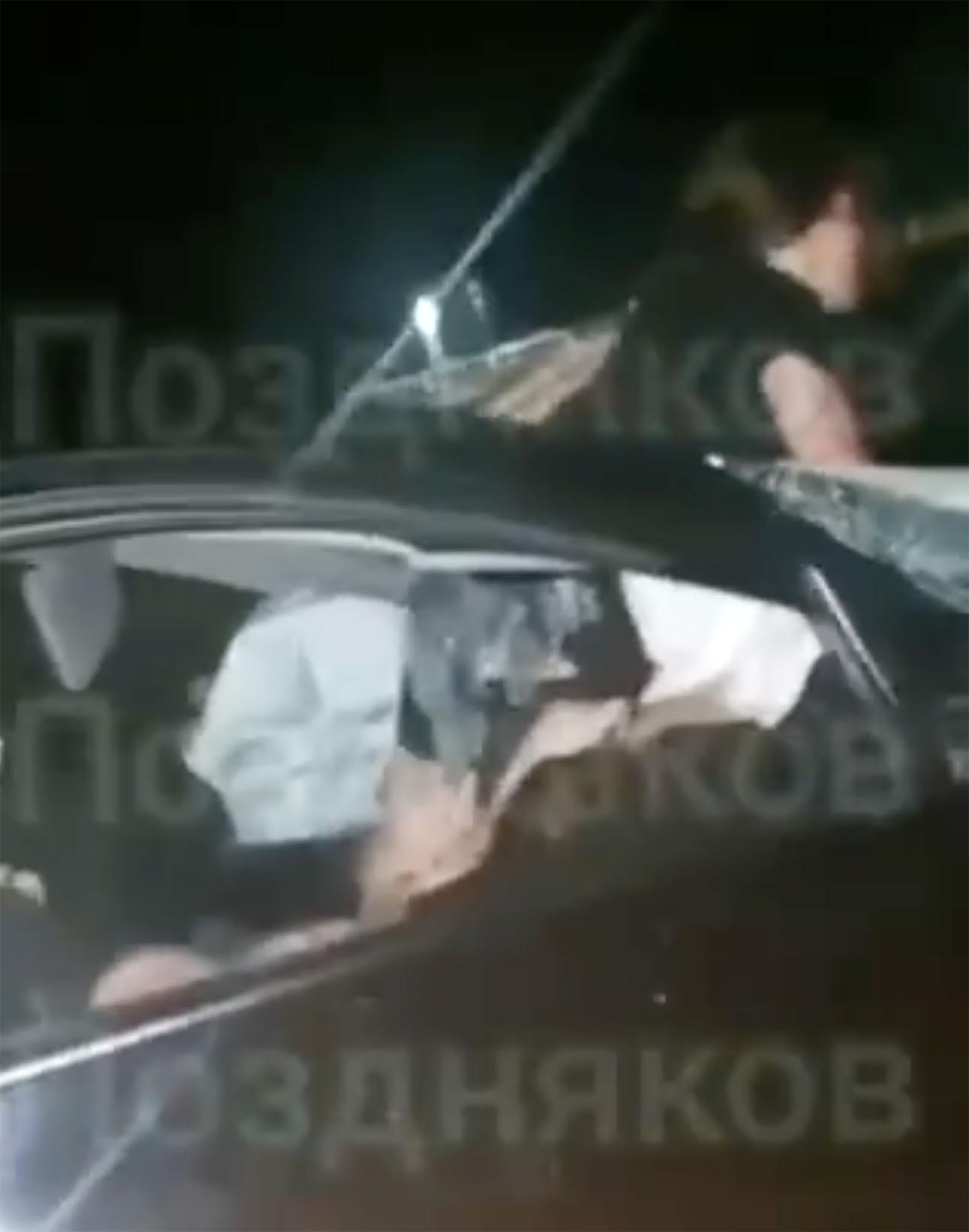 Das Video zeigt eine verwundete Frau in einem schwarzen Fahrzeug, die von Autofahrern unterstützt wird