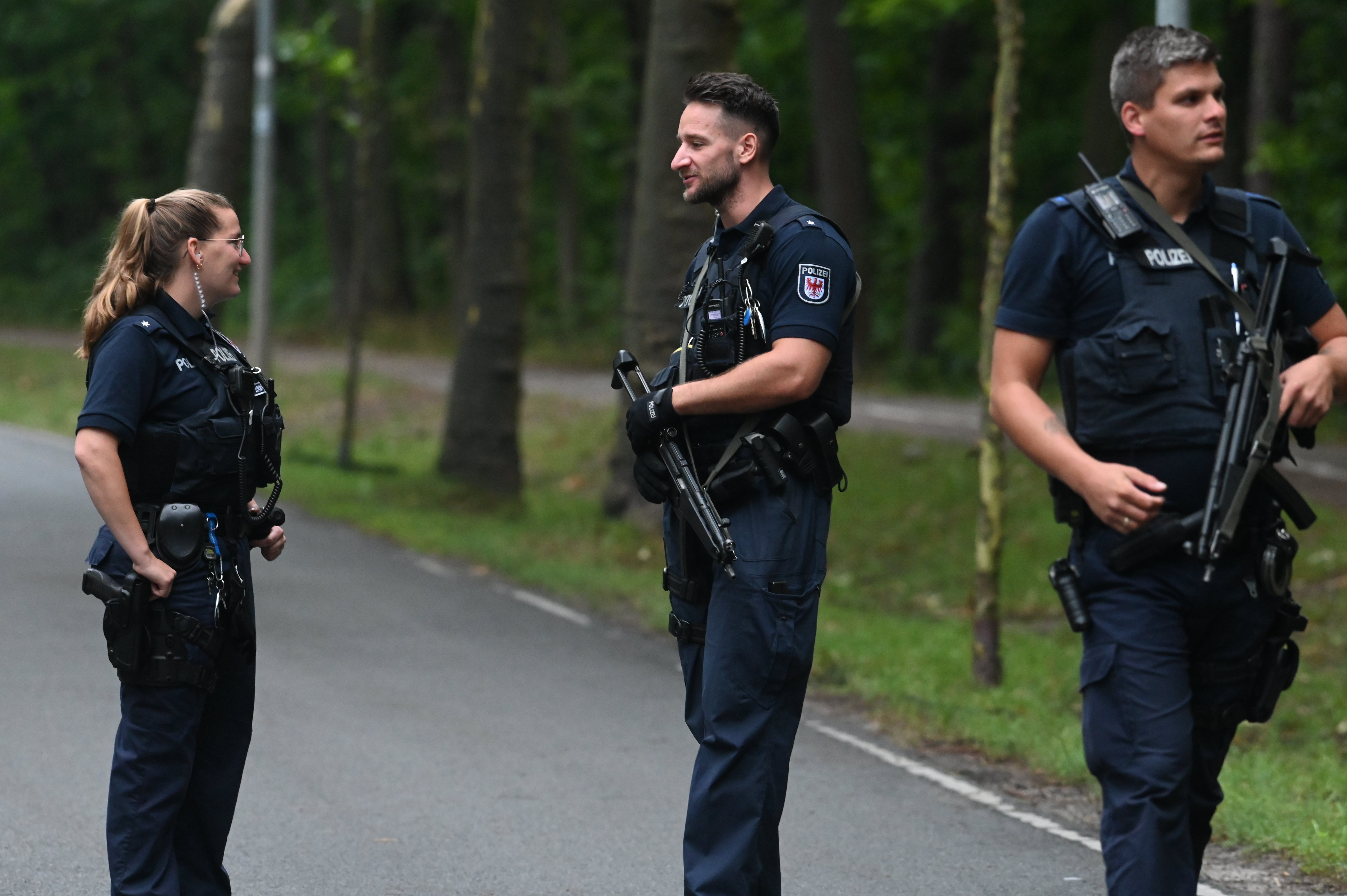 Deutsche Polizisten mit großen Waffen durchkämmen die Gegend nach der angeblichen Raubkatze