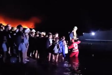 Schrecklicher Moment: Touristen werden auf Boote verladen, um vor wütenden Waldbränden zu fliehen