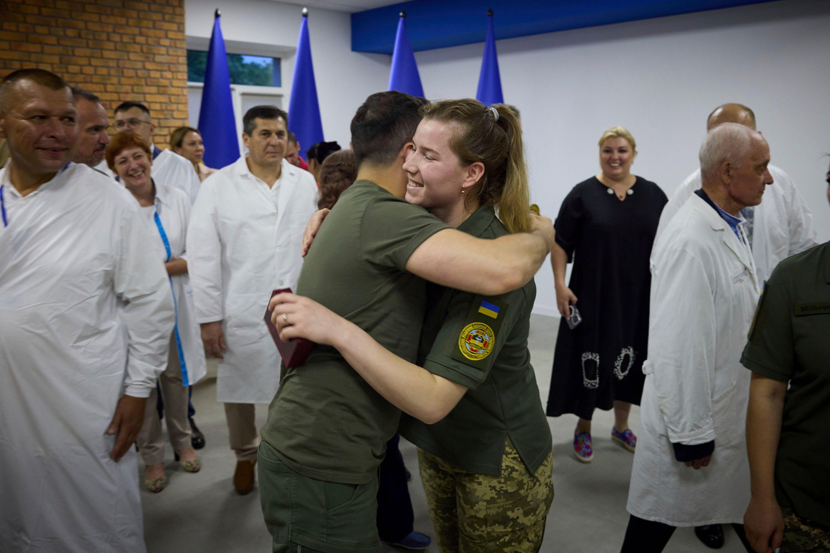 Der ukrainische Präsident umarmt einen Sanitäter, der bei der Behandlung von von Landminen betroffenen Kindern geholfen hat
