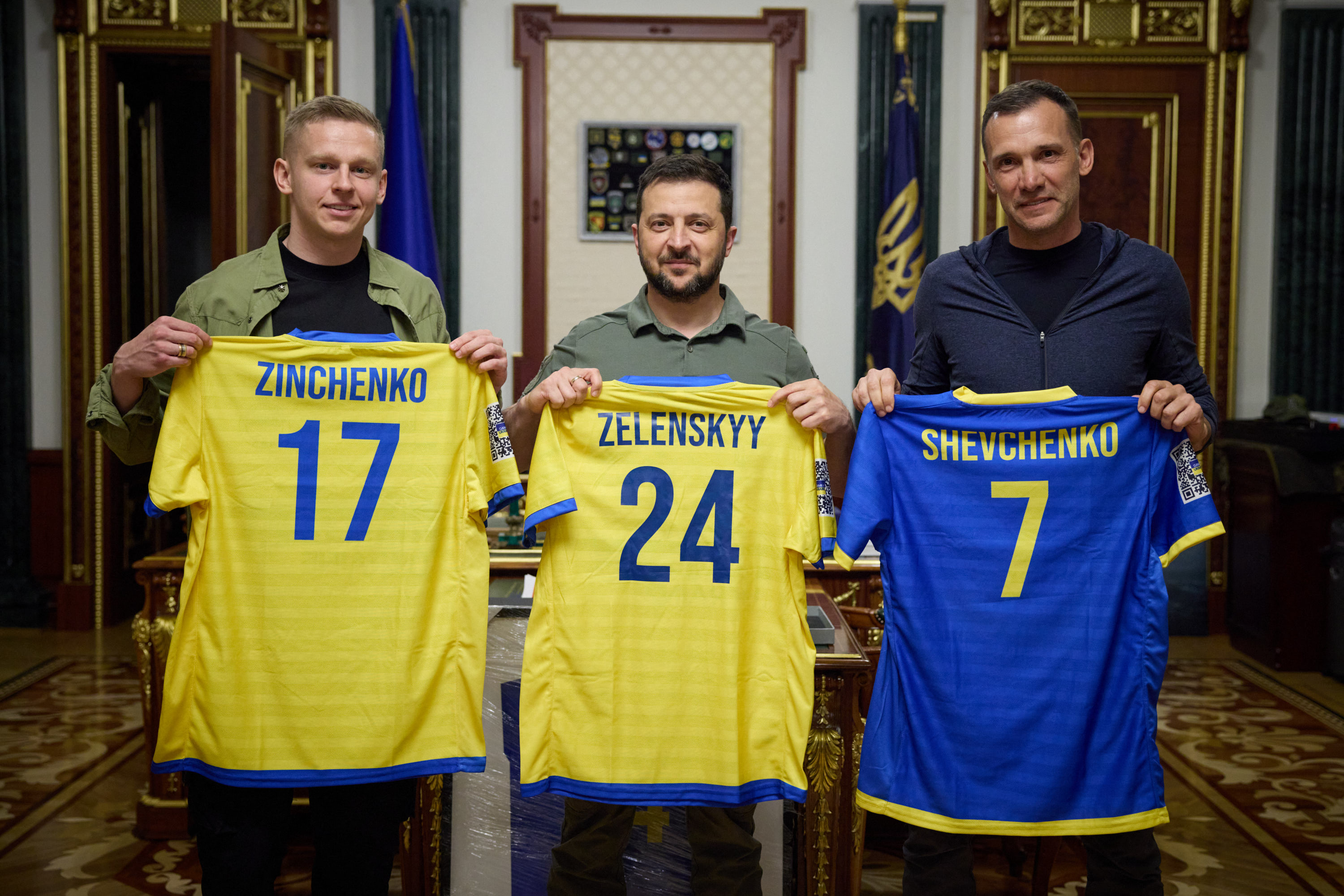 Die Spieler posieren mit Präsident Selenskyj, während sie Pläne für die Spendenaktion bekannt geben