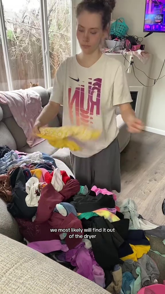 Bevor sie alle Kleidungsstücke in ihr Wohnzimmer bringt, um sie auszusortieren