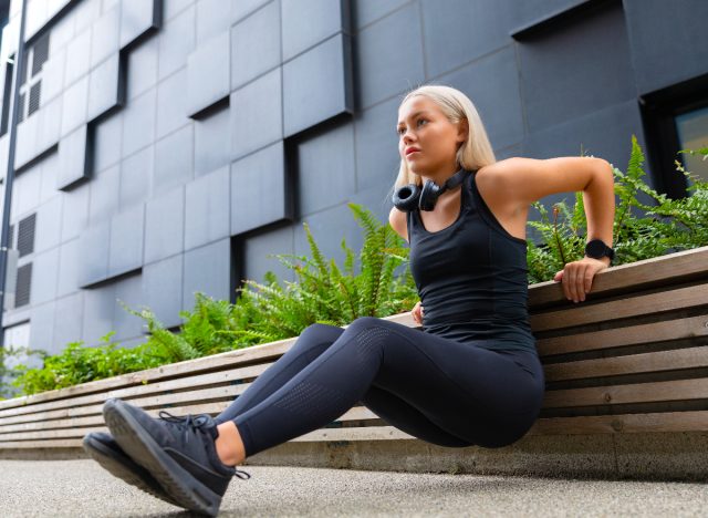 Frau macht Trizeps-Dips im Körpergewicht, Konzept von Übungen, um Achselfett loszuwerden
