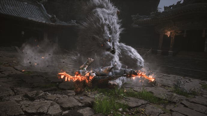 Screenshot von Black Myth Wukong, der zeigt, wie der Charakter einen großen Wolfsfeind mit einem wirbelnden, flammenden Sprungangriff angreift
