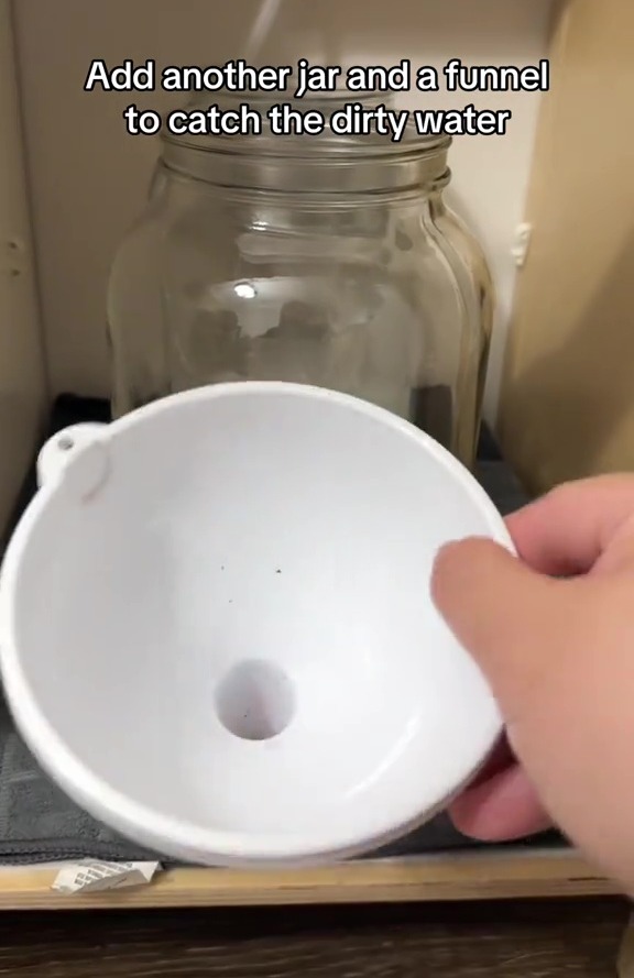 Und stellte ein weiteres Glas mit einem Trichter unter die Spüle, um das schmutzige Wasser aufzufangen
